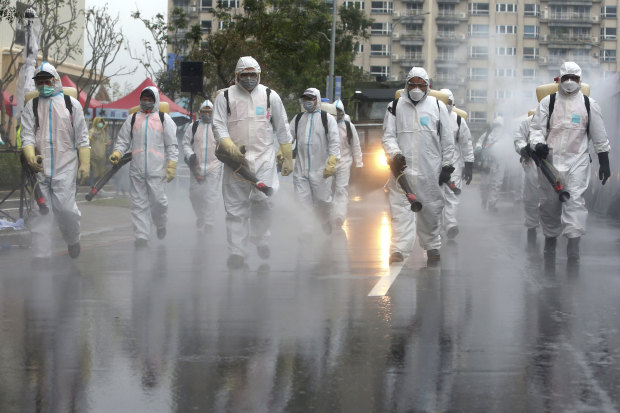 In Taiwan, soliders spray disinfectant in a drill for coping with cluster infections.