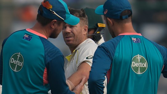 David Warner is examined after suffering a hairline fracture of the elbow during the second Test in Delhi.