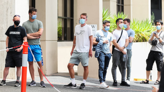 The waiting game ... people associated with the Australian Open line up at a testing facility on Thursday. We must also be patient for proof before demanding any treatments.