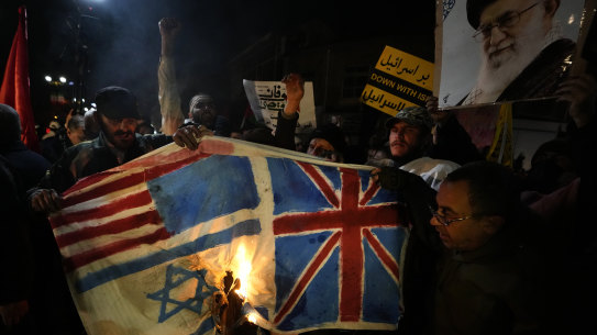 Iranian demonstrators burn representations of British, US and Israeli flags outside the British embassy in Tehran during a protest against the US and British military strike against Iranian-backed Houthis in Yemen.
