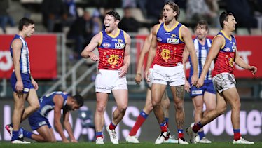 Lachie Neale celebrates with his Lions teammates after kicking a goal against the Kangaroos.