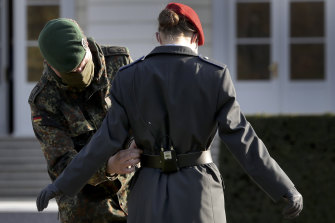 A soldier adjusts the uniform of a recruit prior to an oath-taking ceremony of the German army at the Bellevue palace in Berlin in 2020. With the war in Ukraine, there’s a new push for Germany to reintroduce conscription.