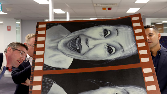 Then Premier Dominic Perrottet, the Minister for the Arts Ben Franklin and Member for Sydney Alex Greenwich pictured looking at the flood damaged artworks from Lismore art gallery that are being restored by conservators at the Registrar-General’s Building in Sydney in May 2022.
