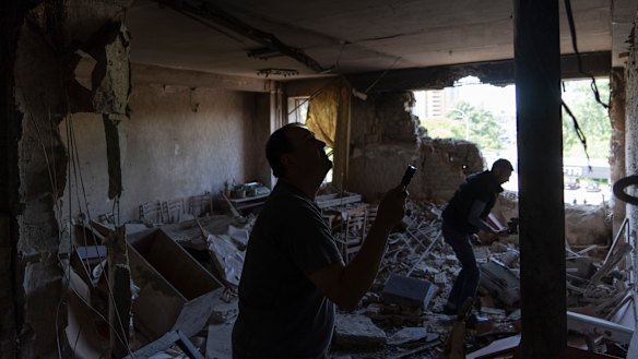 Ukrainians inspect their office damaged in a drone attack on Kyiv on Sunday.