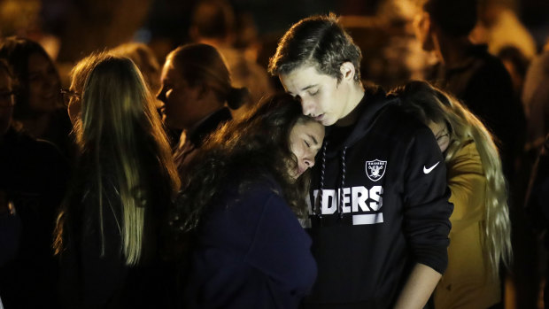 Hannah Schooping-Gutierrez, centre, a student at Saugus High School, is comforted by her boyfriend Declan Sheridan, at right.