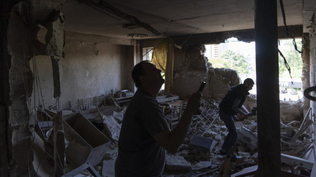 Ukrainians inspect their office damaged in a drone attack on Kyiv on Sunday.