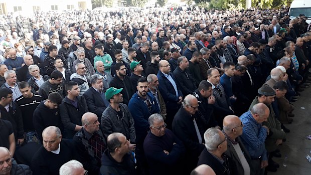 Mourners spill outside the packed mosque where the body of murdered international student Aiia Maasarwe was taken.