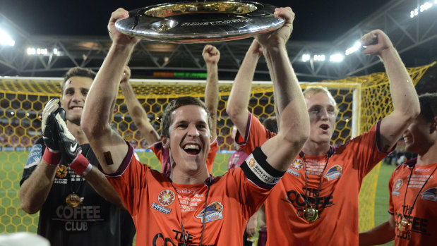 Matt McKay celebrates winning the A-League grand final with Brisbane Roar teammates in 2011.