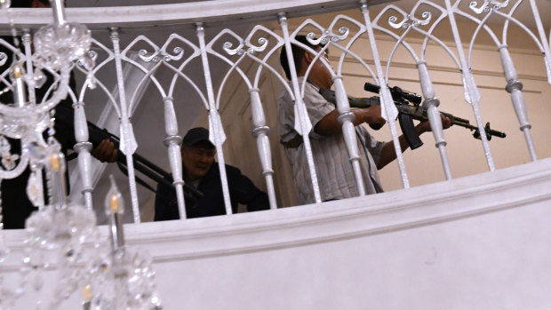 Supporters of Kyrgyzstan's ex-president Almazbek Atambayev hold their weapons during the raid at his home.
