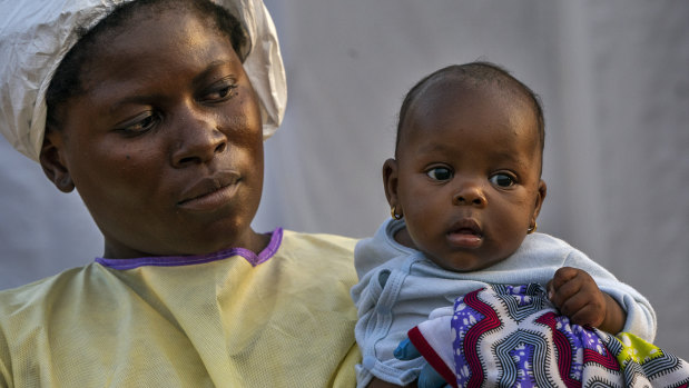 Two-month-old Lahya Kathembo is carried by a nurse waiting for test results at an Ebola treatment centre in Beni, Congo. Her mother and father succumbed to Ebola, but she tested negative.