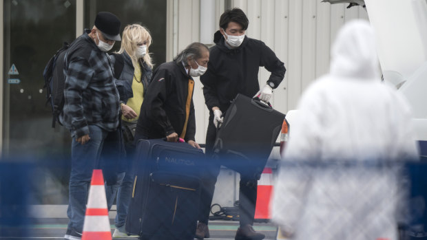 Passengers disembark the quarantined Diamond Princess. 