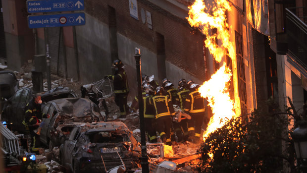 Fire-fighters carry a victim next to a damaged building at Toledo Street following a powerful explosion in downtown Madrid, Spain.