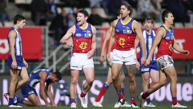 Lachie Neale celebrates with his Lions teammates after kicking a goal against the Kangaroos.