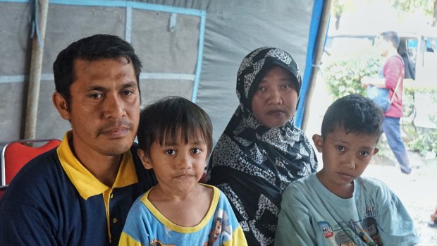 Amirudin U. Labugis (left) and his family after his house was swept away in a "tsunami of mud" following the earthquake in Sulawesi.