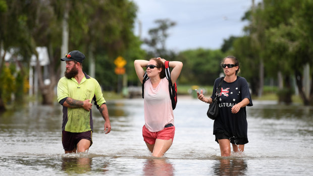 Local residents wade through flood water  in Townsville, Queensland, in February this year.