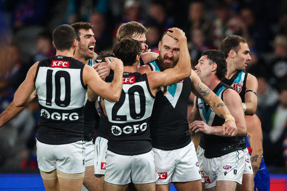 Charlie Dixon is mobbed after kicking a goal, one of his four for the match.