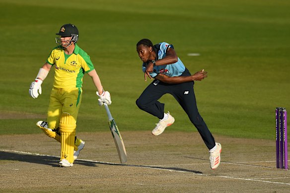 Archer bowls as Warner watches on.