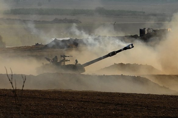An Israeli tank fires a round during the Gaza conflict on October 16, 2023.