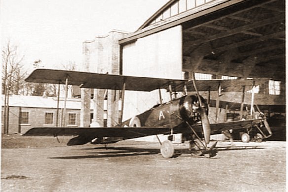 An Avro 504K aircraft of the Australian Flying Corps outside hangars at Leighterton aerodrome. An ‘A’ is painted under the front cockpit.