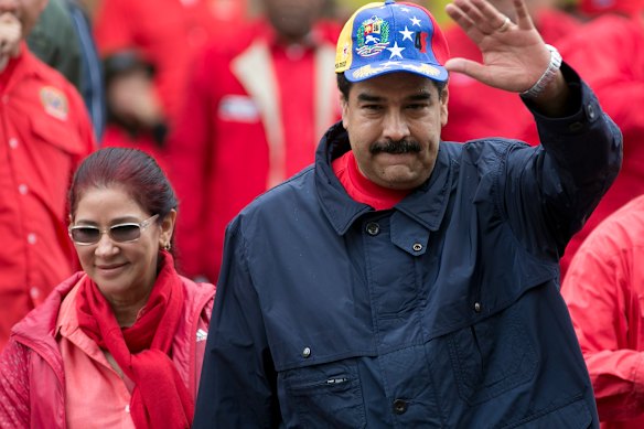 Maduro waves to supporters alongside first lady Cilia Flores in Caracas in 2016.