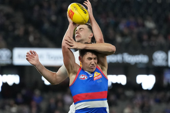 Anthony Scott of the Bulldogs marks the ball under pressure from Jordan Clark of the Dockers.