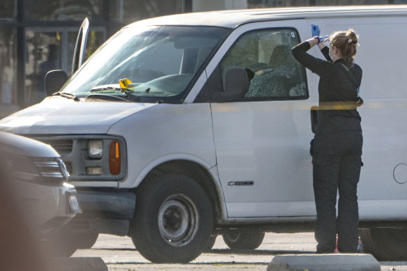 A forensic photographer gets ready to take pictures of a van’s window and its contents in Torrance, California.