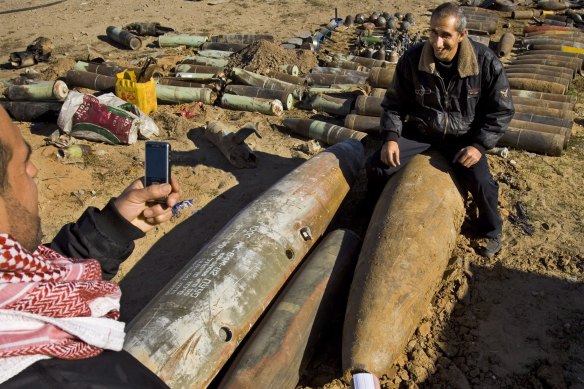 A Palestinian man has his photo taken next to unexploded Israeli ordnance in a 2009 file photo.