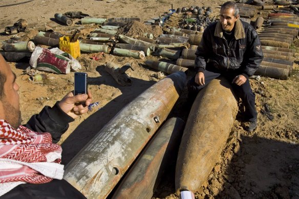 A Palestinian man has his photo taken next to unexploded Israeli ordnance in a 2009 file photo.