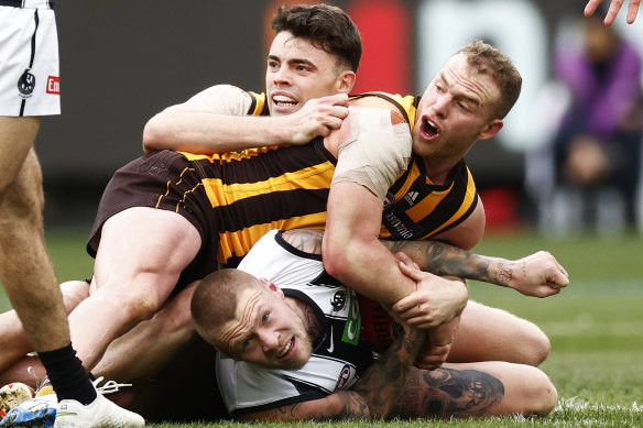 Hawks Tom Mitchell and Conor Nash tackle Jordan De Goey.