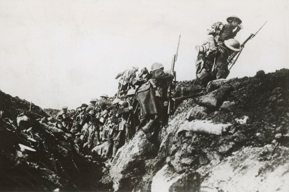 Australian infantrymen clamber over the top of a trench in France on a bayonet charge towards the German lines.