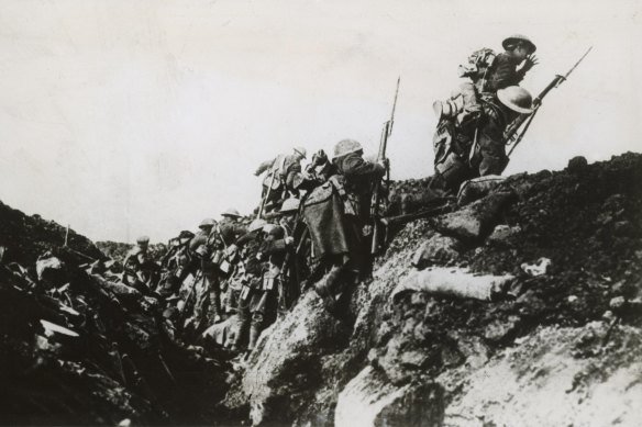 Australian infantrymen clamber out of a trench on the Western Front in France on a bayonet charge towards the German lines.