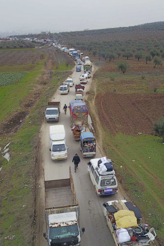 Trucks ferry civilians out of Idlib to find safety inside Syria near the border with Turkey on February 11.