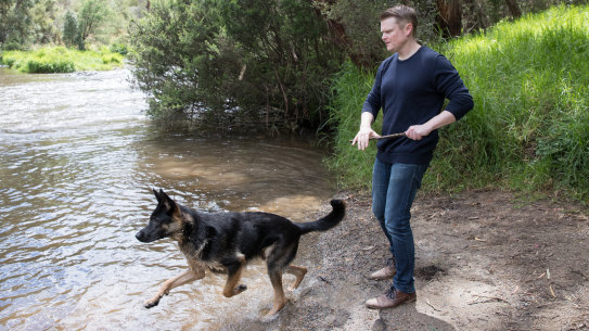Keith Wolahan plays with his dog Jet at the river in Warrandyte