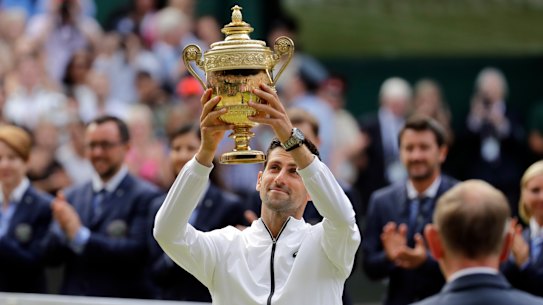 Novak Djokovic lifts the Wimbledon men's trophy for a fifth time.