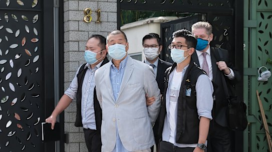 Jimmy Lai, chairman of Next Media Ltd., second left, is led away from his residence by law enforcement officials in Hong Kong on Monday. 