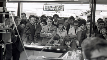 Crowds gather around a television set at Sydney Airport to watch the broadcast of American astronaut Neil Armstrong becoming the first man to walk on the moon, July 21, 1969.