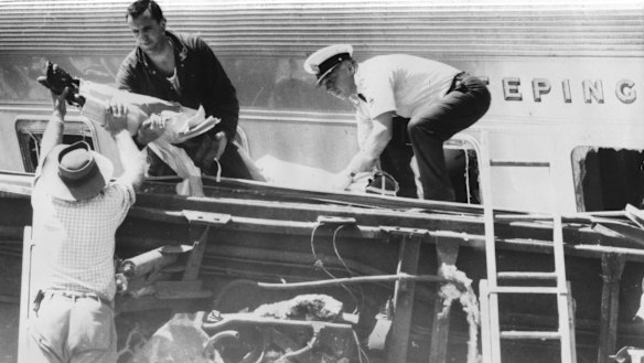 Rescuers use ladders, stretchers and man power to bring casualties down from the piled wreckage of the sleeping cars.