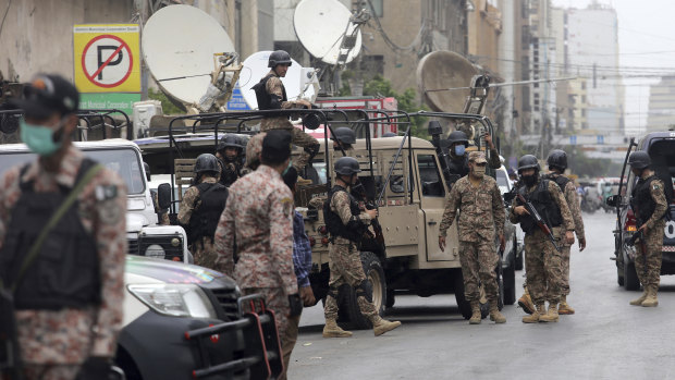 Security personnel surround the stock exchange after an attack in Karachi, Pakistan.