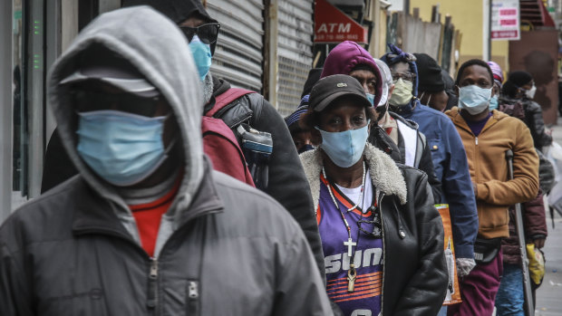 People wait for a distribution of masks and food in Harlem.