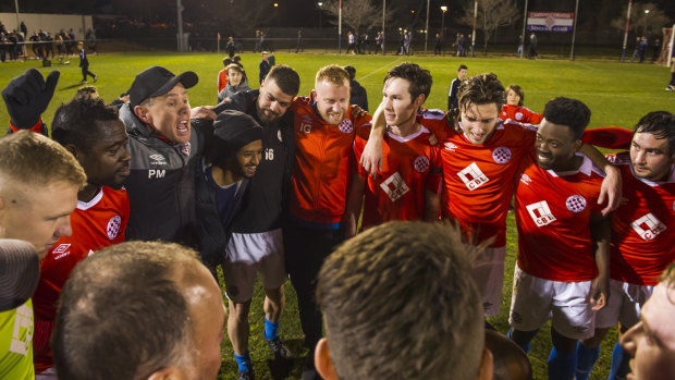 Canberra FC celebrate winning the grand final earlier this year with coach Paul Macor. 