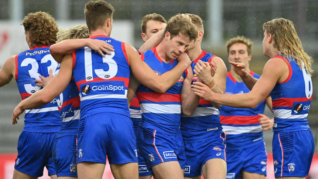 Mitch Hannan is congratulated by his teammates after slotting a goal in the elimination final against Essendon.