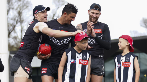 Brayden Maynard, Scott Pendlebury and Jeremy Howe with a couple of young fans who were Magpies team mascots for their preliminary final.