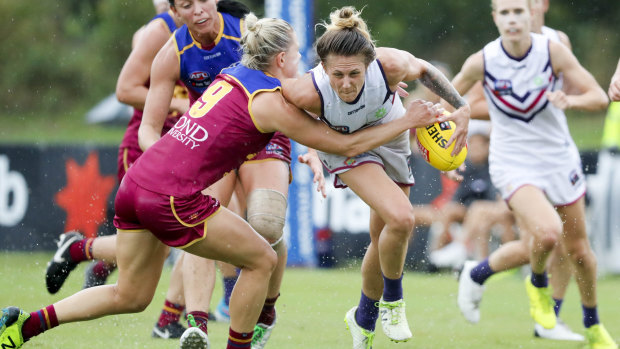 Dangerous player: Kate McCarthy lays a tackle on Melissa Caulfield.