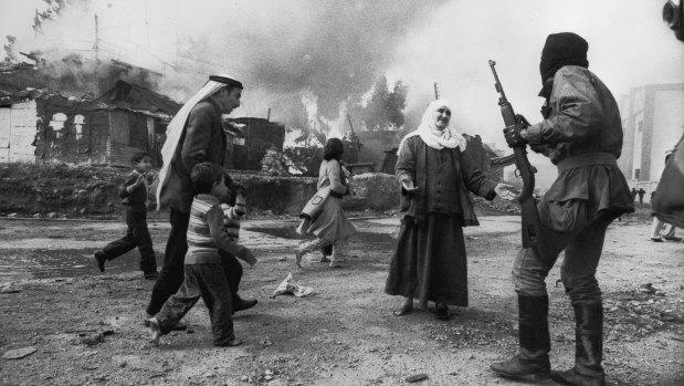 A Palestinian woman pleads with a Christian militiaman in Beirut while a man tries to take children to safety during the Lebanon war in 1976. 