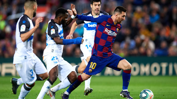 Lionel Messi eludes Ruben Duarte, Wakaso Mubarak and Manu Garcia of Deportivo Alaves before scoring his team's third goal at Camp Nou.