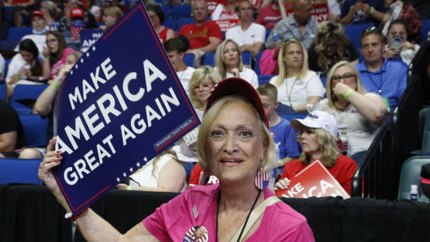 A Trump worker hands out signs before the campaign rally in Tulsa.