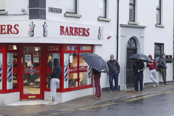 People queue outside a barber's shop in Athy in the Irish county of Kildare after restrictions were eased on June 29. The county has now gone back into partial lockdown.