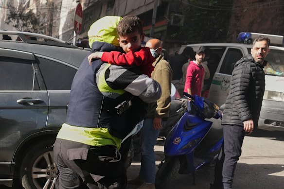 A rescue worker carries a child at the scene of an Israeli airstrike in Beirut.