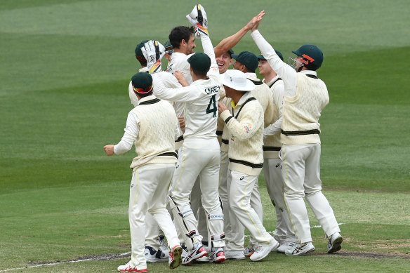 Mitchell Starc of Australia is congratulated by teammates after running out of Keshav Maharaj of South Africa.