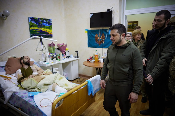 Ukrainian President Volodymyr Zelensky visits a wounded soldier at a hospital in Kyiv. 